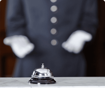 A bell and gloves on the table in front of a person.