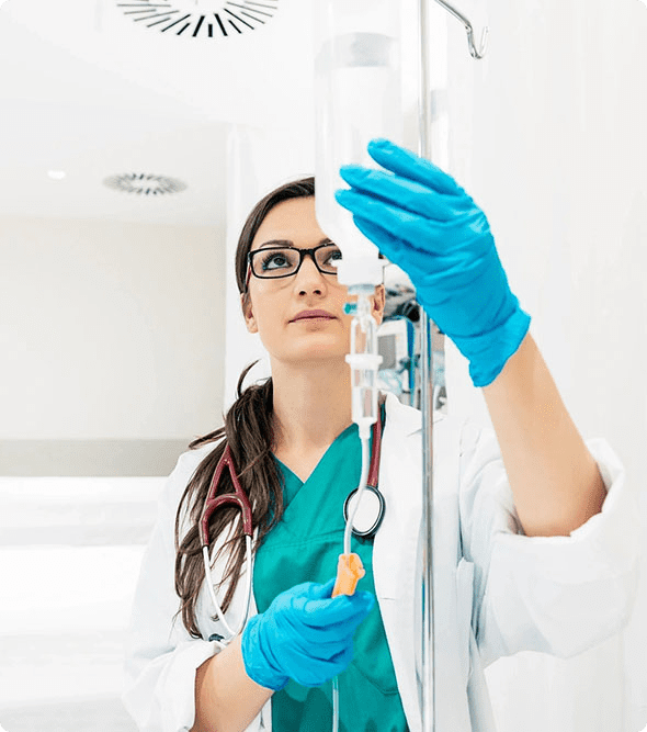 A woman in blue gloves holding a syringe.