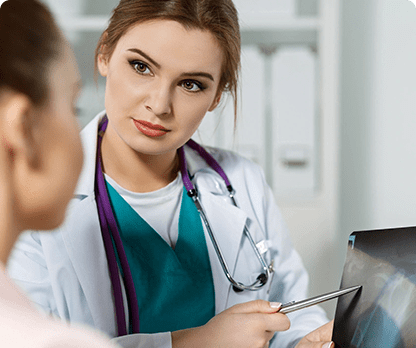 A woman in white lab coat and stethoscope looking at an x-ray.