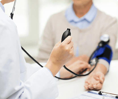 A doctor is checking the blood pressure of an older person.