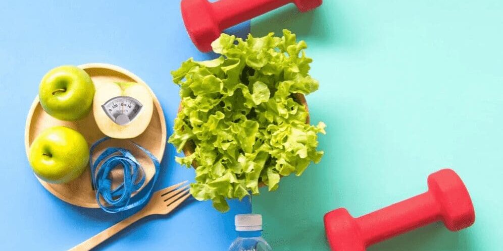 Healthy lifestyle with dumbbells, salad, and apples.