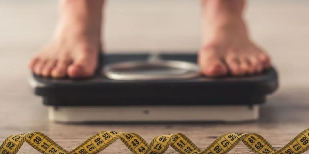 A person standing on a scale with tape around it.